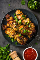 Grilled meat with herbs on black top view.