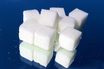 Piece of sugar on the glass close-up. Blue background. Sweet.