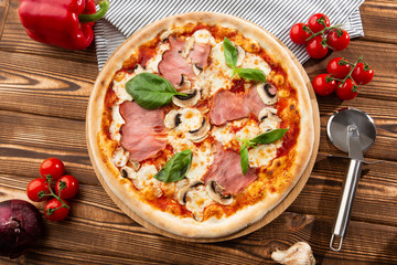 Italian Delicious Fresh Hot Mix Baked Pizza with Melting Cheese, sliced mushrooms , ham, tomato sauce and cheddar serving on textured rustic background. top view.
