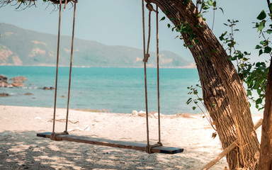 Wood cradle under tree on the beach with sea background