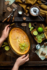 Overhead shot of homemade casserole, pudding, cheesecake, tart, pie or mousse with slices of lime on top 