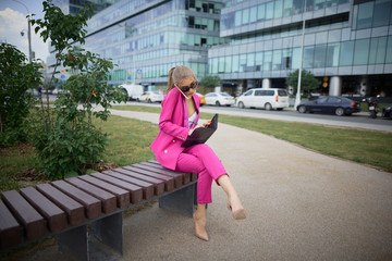Fototapeta na wymiar Business woman sitting on a bench in the street