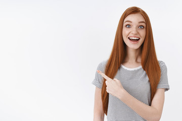 Amused surprised enthusiastic wondered redhead young cute ginger girl wearing striped t-shirt drop...