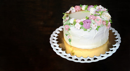 SWEET FLORAL BUTTERCREAM BIRTHDAY, ANNIVERSARY OR MOTHERS DAY CAKE AGAINST DARK WOODEN BACKGROUND