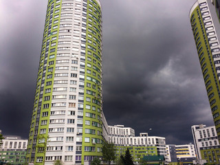 High-rise residential complex on a background of dark sky with thunderclouds