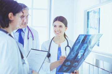 Smiling doctors discussing patient's diagnosis looking at x-rays in a hospital