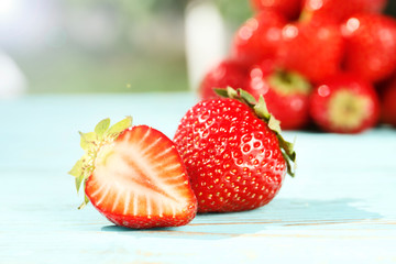 Ripe juicy strawberries close-up on a wooden background in the summer garden. Top view