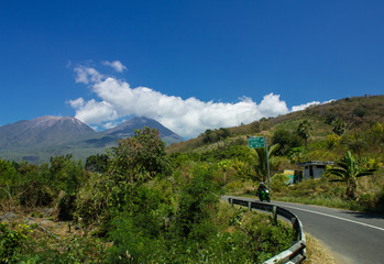 A Landscape of Lewotobi mountain, a twins volcano, street path and motorcycle from Larantuka, East Nusa Tenggara, Indonesia
