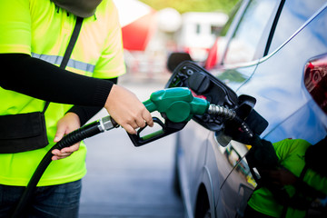 hands refilling the car with fuel at the gas  station.