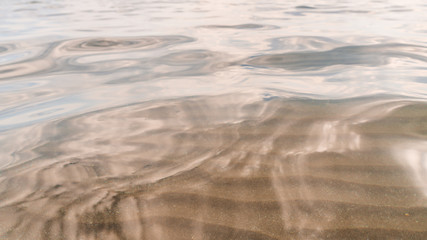 Smooth water surface with sand bottom