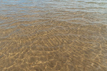 Smooth water surface with sand bottom