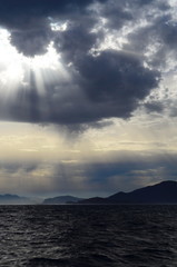 the setting sun in the clouds over the Aegean Sea