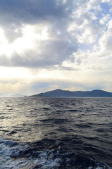 the setting sun in the clouds over the Aegean Sea