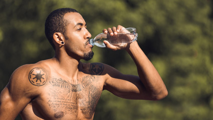 Afro Guy Drinking Water After Workout In Park