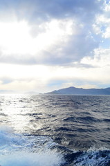 the setting sun in the clouds over the Aegean Sea