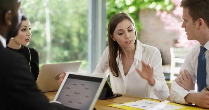 4K Overworked & stressed out businesswoman arguing with coworkers in a meeting. Slow motion.
