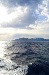 the setting sun in the clouds over the Aegean Sea