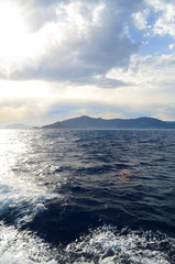 the setting sun in the clouds over the Aegean Sea