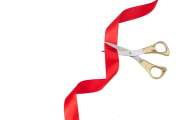 Fotobehang Grand opening. Top view of gold scissors cutting red ribbon on wite background. © vetre