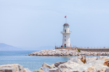 Fototapeta na wymiar A white lighthouse stands on the coast of Alanya, Turkey.