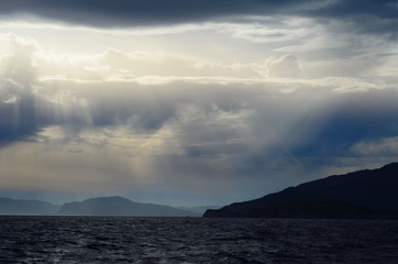 the setting sun in the clouds over the Aegean Sea