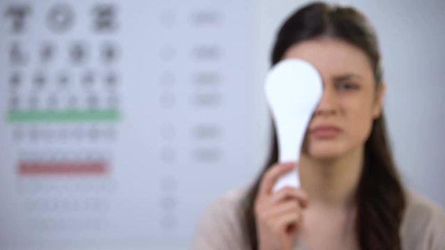 Upset woman with blurred vision closing eye and squeezing eyes, risk of cataract