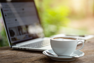 White ceramic coffee cup on wooden table or counter