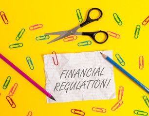 Writing note showing Financial Regulation. Business concept for aim to Maintain the integrity of Finance System Crushed striped paper sheet scissors pencils clips colored background