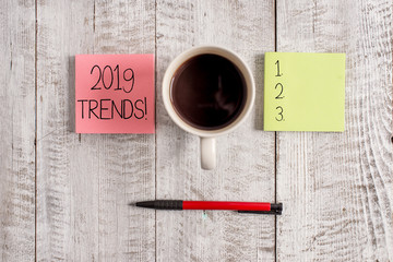 Writing note showing 2019 Trends. Business concept for general direction in which something is developing or changing Stationary placed next to a cup of black coffee above the wooden table