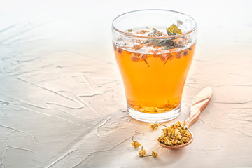 Herbal tea with pharmaceutical chamomile on a white table. Copy space