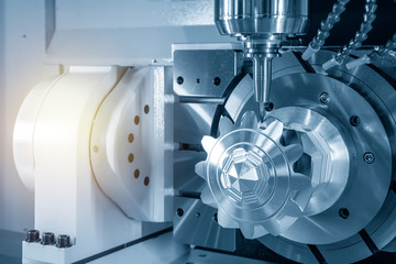The 5-axis CNC milling machine cutting the aluminium gear parts. The hi-technology manufacturing process by machining center. © Pixel_B