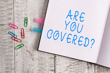Text sign showing Are You Covered Question. Business photo text asking showing if they had insurance in work or life Thick pages notebook stationary placed above classic look wooden backdrop