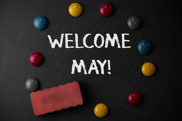 Word writing text Welcome May. Business photo showcasing welcoming fifth month of year usually considered summer Round Flat shape stones with one eraser stick to old chalk black board