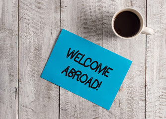 Text sign showing Welcome Abroad. Business photo showcasing something that you say when someone gets on ship Pastel Colour paper placed next to a cup of coffee above the wooden table