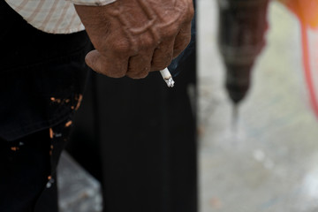 Hand old man holding a cigarette.