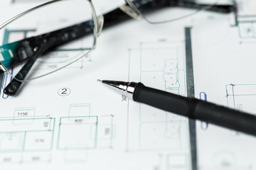 Lying glasses on a schematic plan of interior design