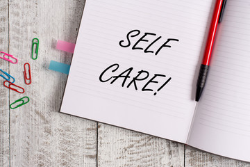 Conceptual hand writing showing Self Care. Concept meaning practice of taking action preserve or improve ones own health Notebook stationary placed above classic wooden backdrop