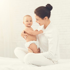 Young mother hugging her cute newborn child