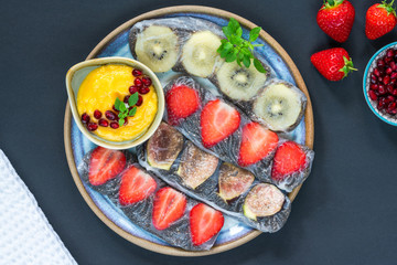 Chia seeds and fruit rice paper rolls with mango dipping sauce - top view