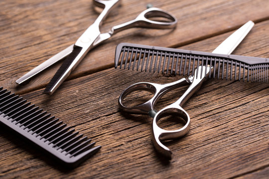Barber tool. Barber scissors. Scissors and hairbrush on vintage wooden background.
