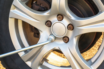 Replacing the wheels on the highway, unscrewing the nuts with a wrench