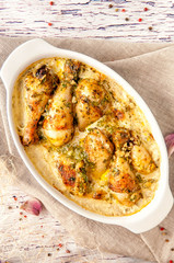 Fried chicken cooked in a creamy sauce with garlic. Large portion in a deep dish. Close up and vertical view.