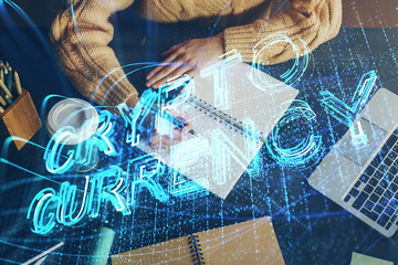 Cryptocurrency hologram over hands taking notes background. Concept of blockchain. Multi exposure