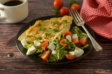 Healthyfood - egg omelette with cherry tomato, mozzarella and green salad. Traditional breakfast.