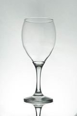 Empty wine glass silhouette, white background.