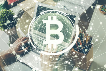 Crypto currency theme hologram with businessman working on computer on background. Concept of...