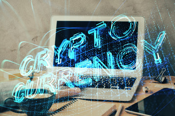 Crypto currency theme hologram with businessman working on computer on background. Concept of blockchain. Double exposure.