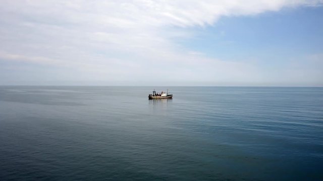 Aerial of large trawler fishing boat vessel in the middle of the ocean
