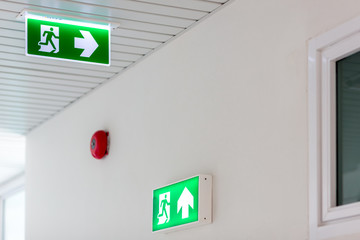 Green emergency exit sign showing the way to escape.Fire exit in the building.