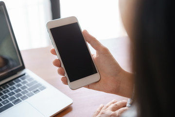 Blank digital smartphone in the hand of Asian business woman, Mobile phone black screen, Shoulder View of women work from home
